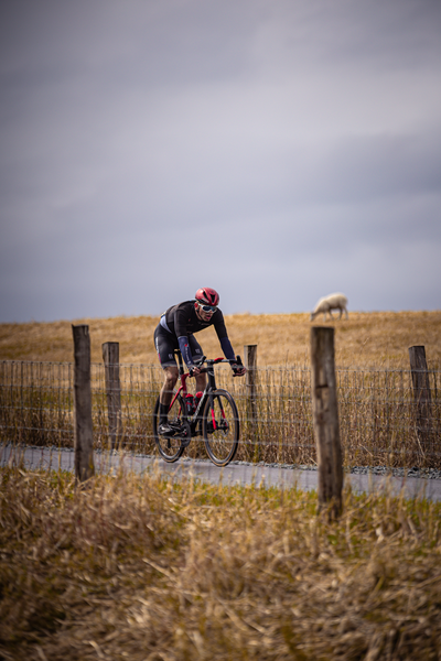 De man is in de middel van het Nederlands Kampioenschap en is op een fiets.