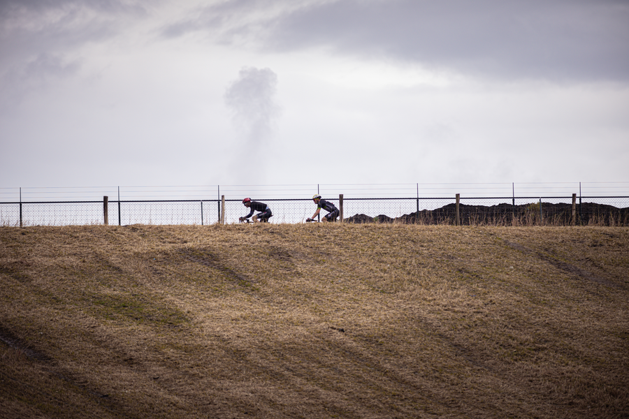 A group of cyclists wearing red helmets on the side of a hill.