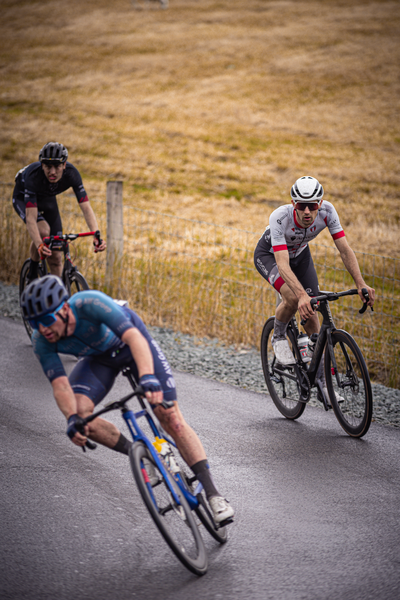 A black and white photo of cyclists racing on a track.