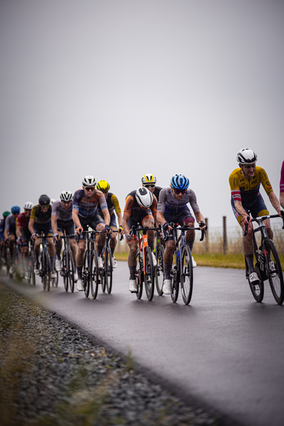 Mannen Elite ZC cyclists racing on a paved surface.