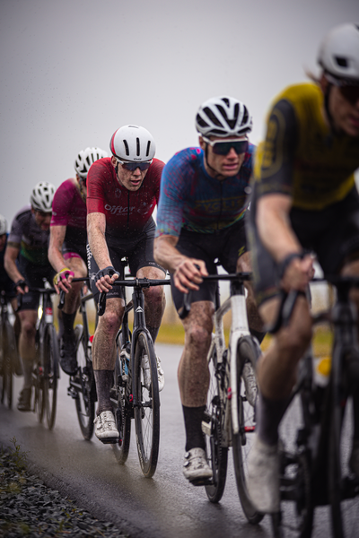 A group of cyclists race together in the Nederlands Kampioenschap Wielrennen Mannen Elite ZC.