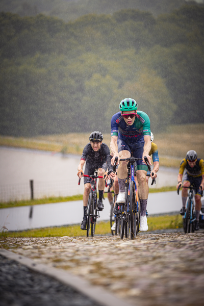 A group of cyclists racing together in a race on a course.