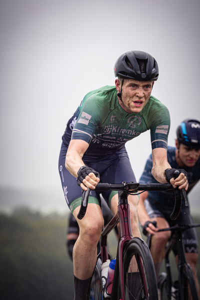 A man in a green jersey is riding on his bicycle at the 2024 Nederlands Kampioenschap.