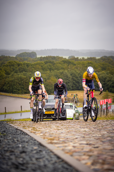 The cyclists are participating in the Nederlands Kampioenschap and are sponsored by Wielrennen.