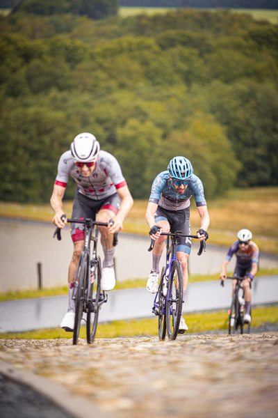 A man wearing a blue helmet is leading the pack in this race.