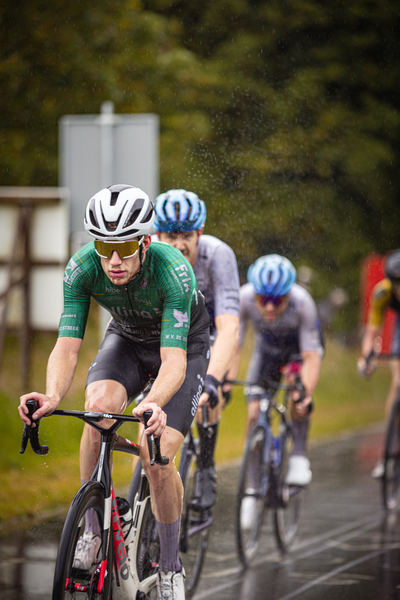 A man in a green jersey rides his bike as he competes in the Nederlands Kampioenschap.