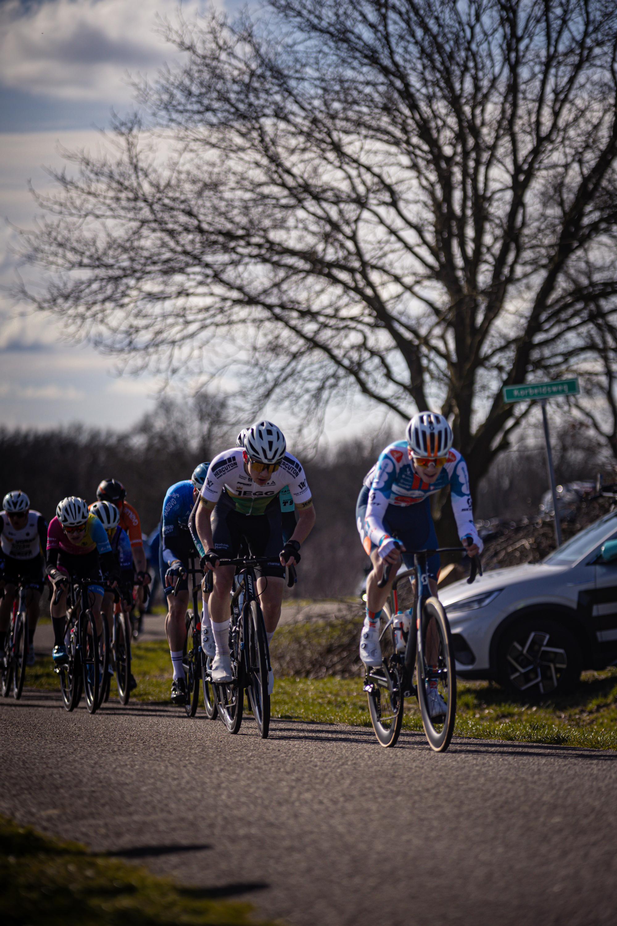 The cyclists are racing down a street in Ster van Zwolle.