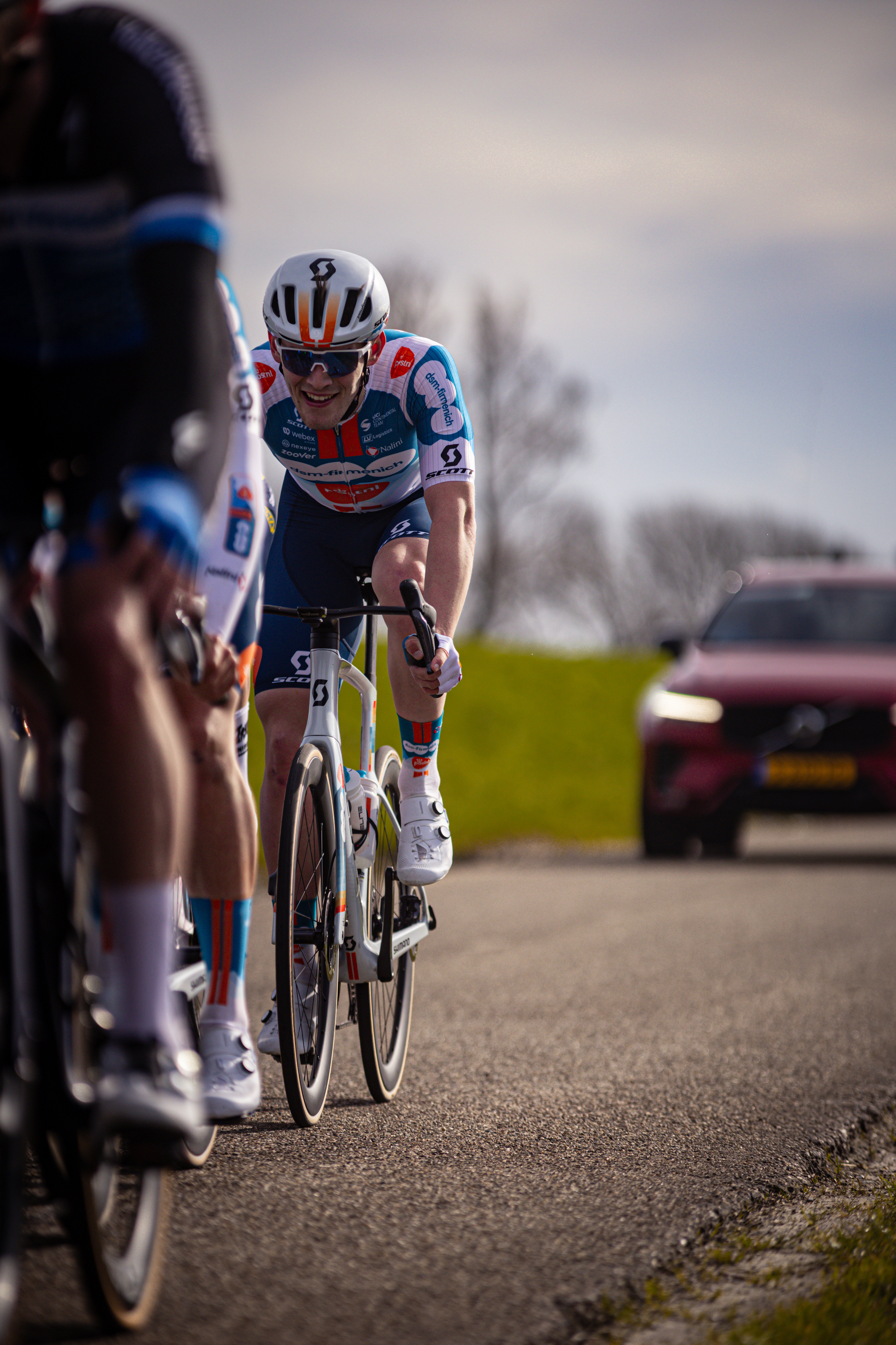 A man wearing a blue and white shirt riding his bike with the number 23 written on it.