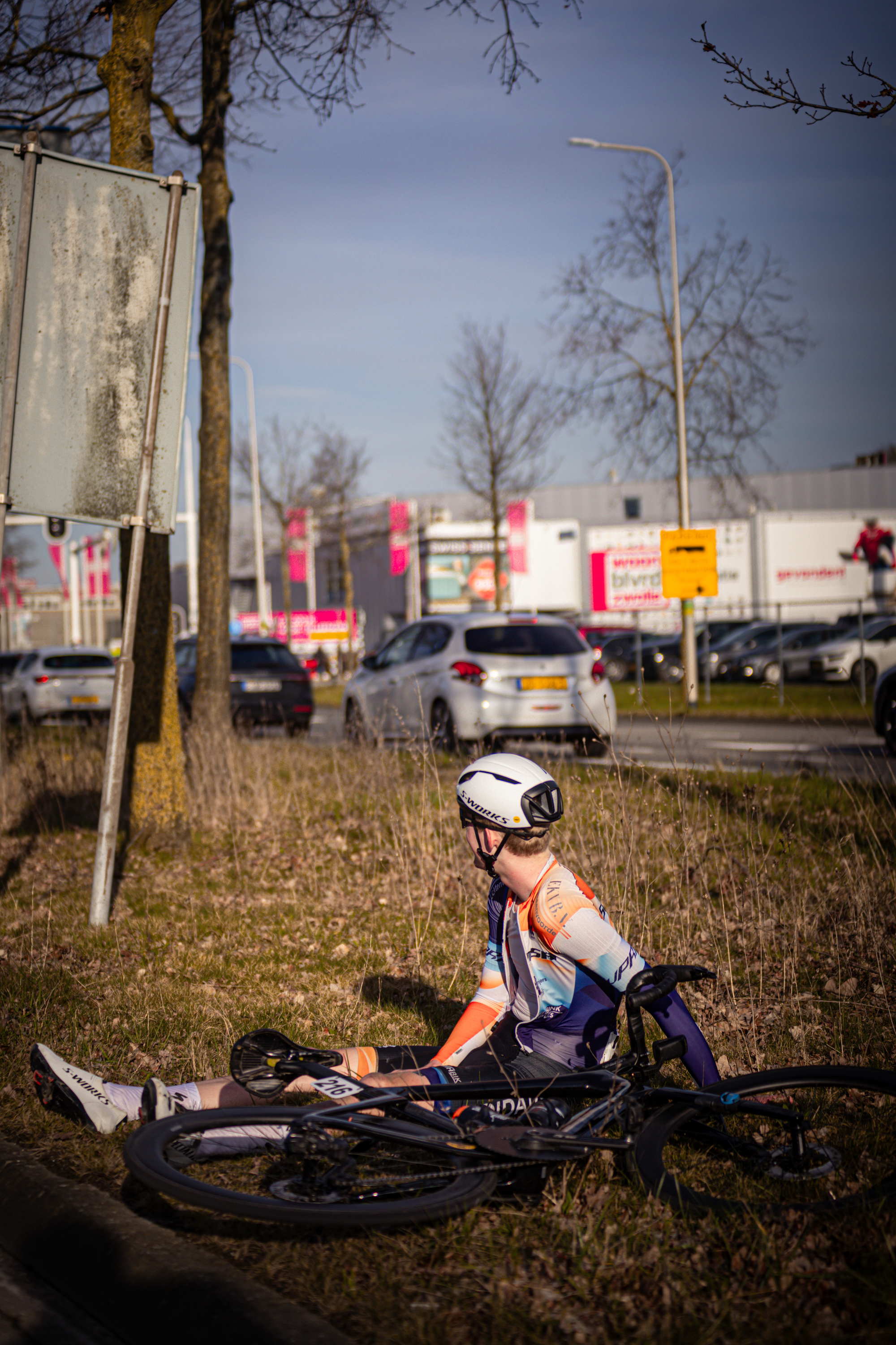 A person in a white helmet is sitting on a bike near a sign that says "Ster van Zwolle".