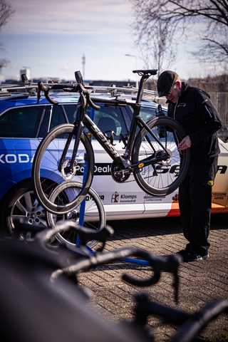 A man is preparing to mount his bicycle on a vehicle.