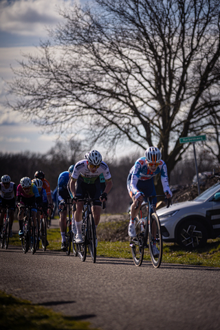 The cyclists are racing down a street in Ster van Zwolle.