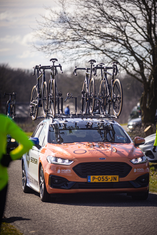 A bike rack is on top of a car, which says P-055-N on the front.