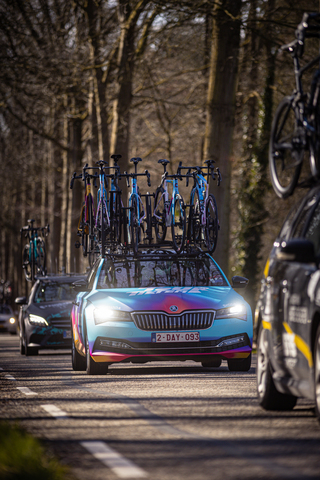 Bike carrier on top of a blue car with the word Wielrennen on it.