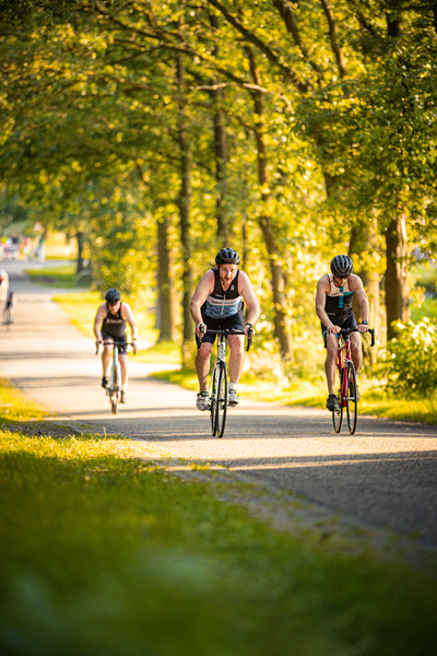 Two people are riding bikes on a trail and they both have a number 4 on the front of their bike.