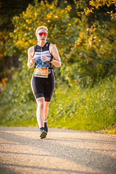 A runner on a trail with the word triathlon written on their shirt.