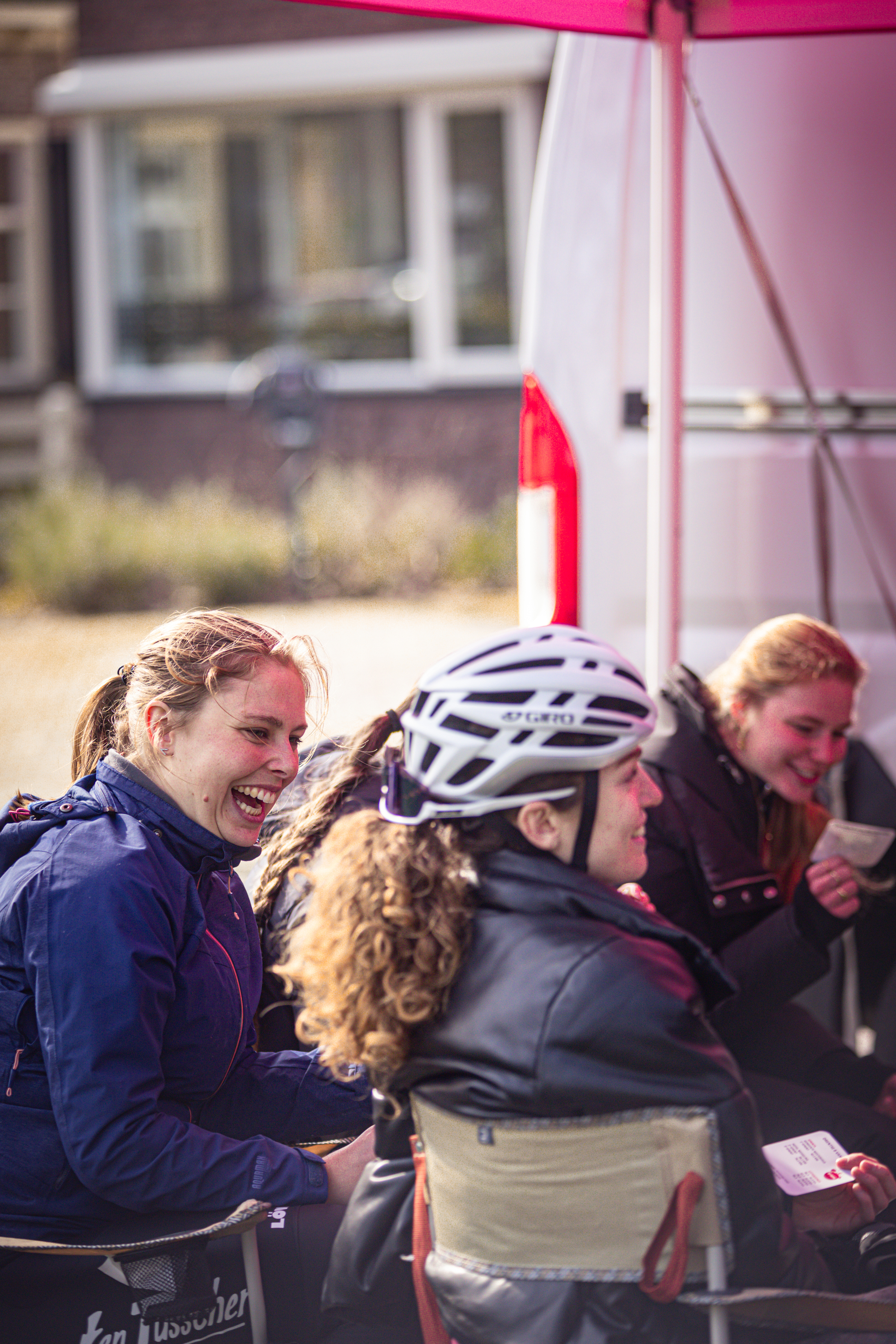 A woman wearing a helmet sits at the Wielrennen event.