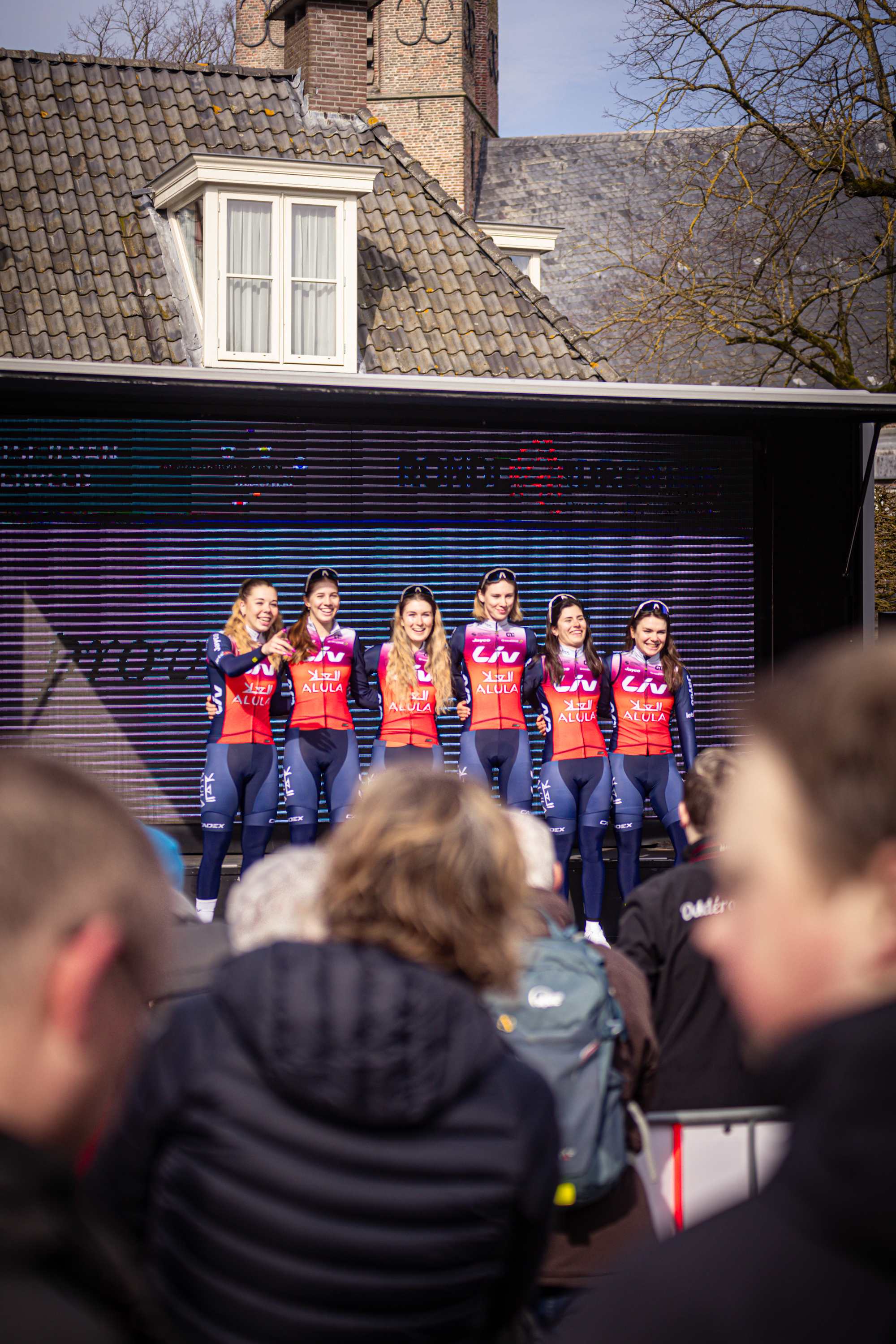 Group of cyclists posing for a photo in front of a brick building on Drentse 8 van Westerveld.