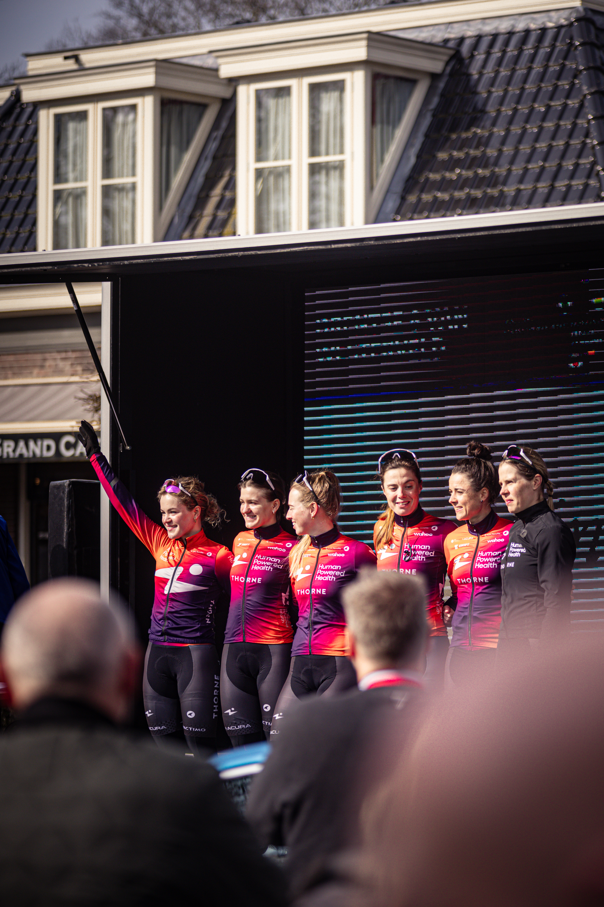 Several women in pink and purple jerseys are posing for a photo, with the word "Land" visible in the background.