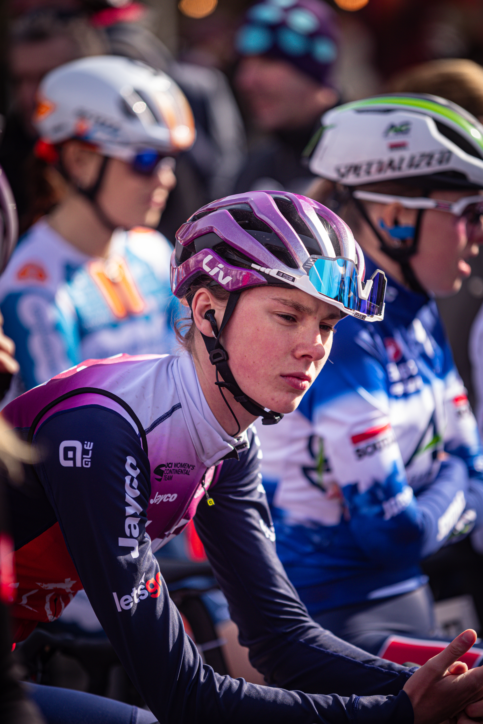 Several people with helmets sit next to each other.