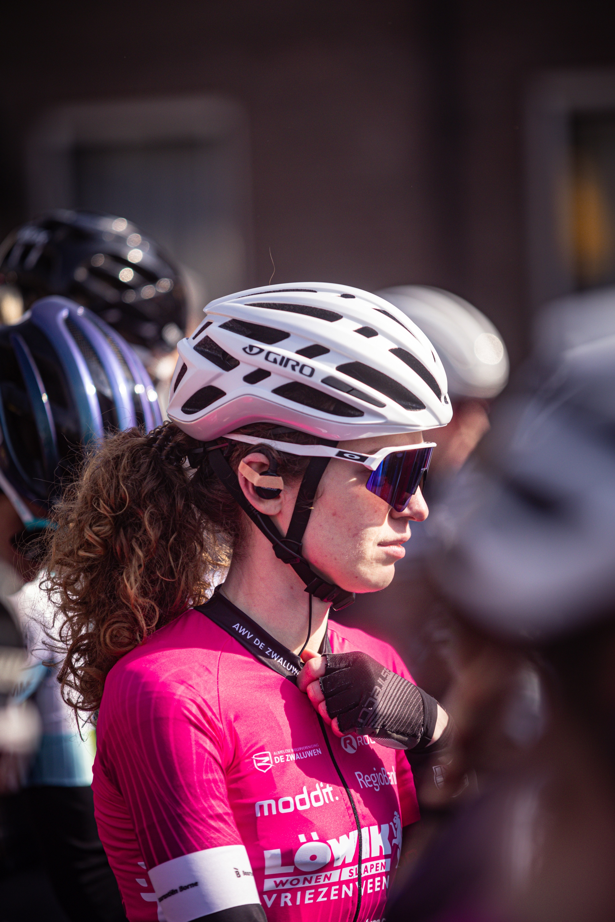 A woman wearing a pink jersey that says "moderatie" is standing in front of another person.