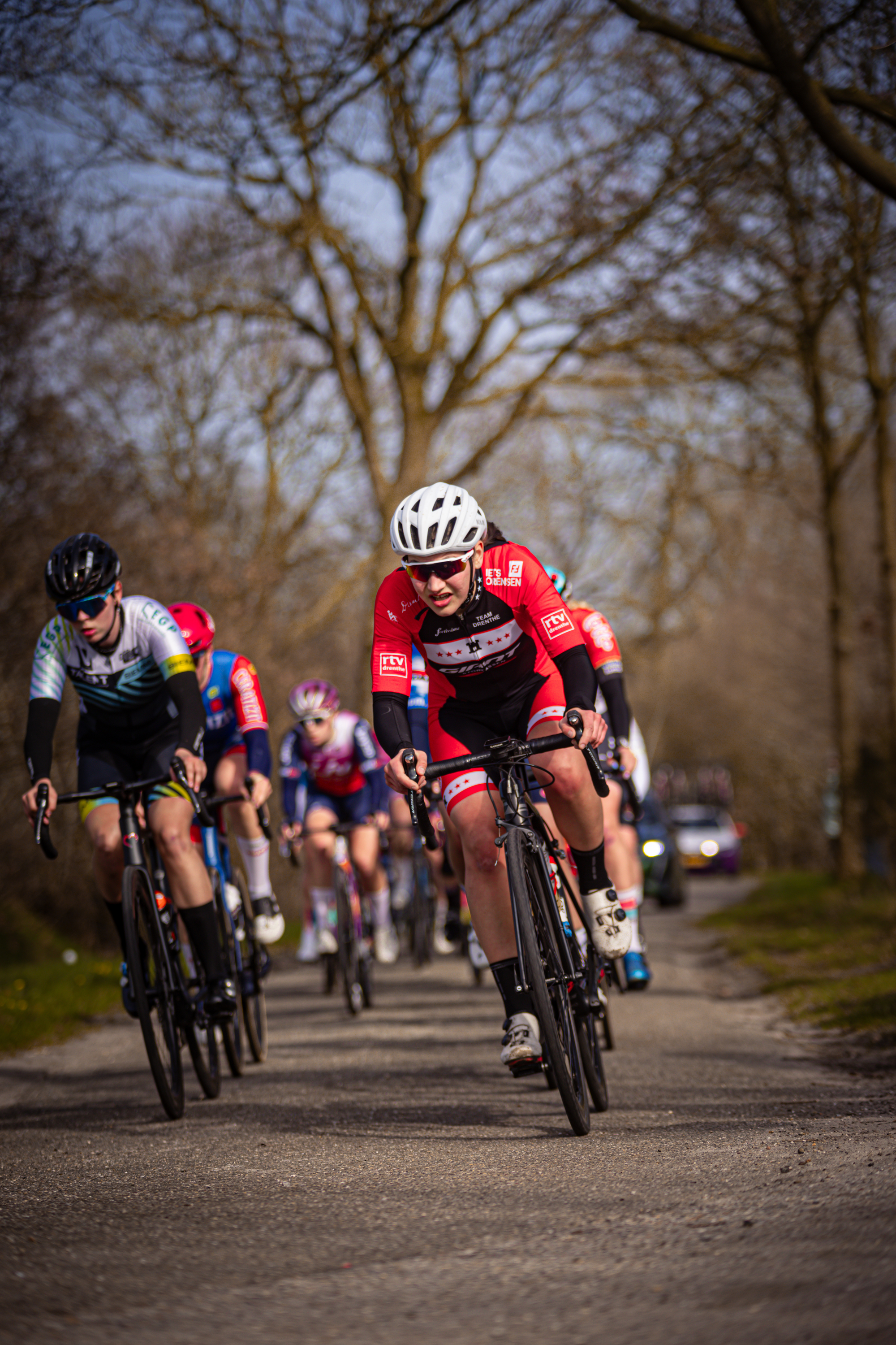 A group of cyclists are racing down a road during the Drentse 8 Van Westerveld race.