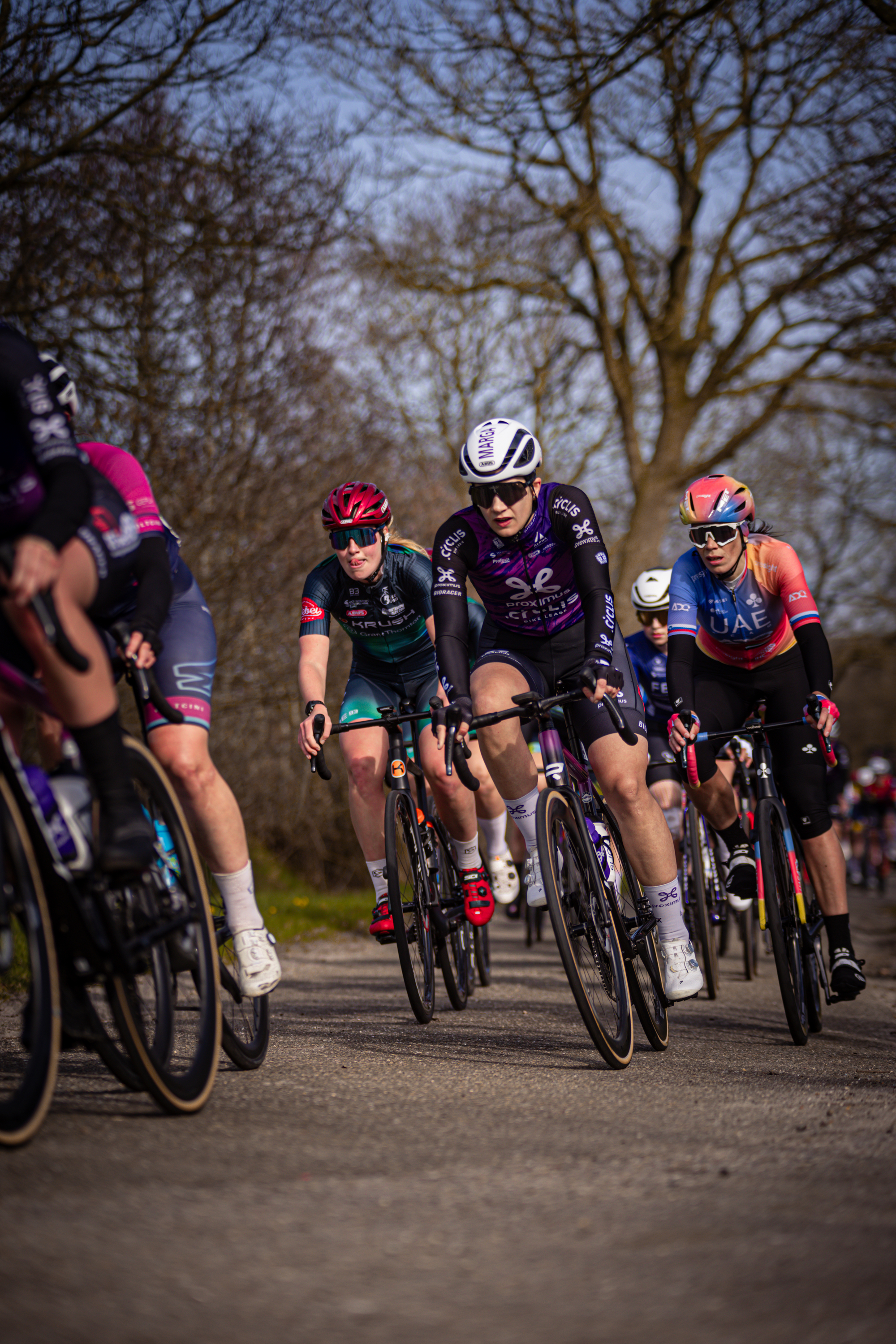 A group of cyclists are participating in a race, with one cyclist wearing the number 21.