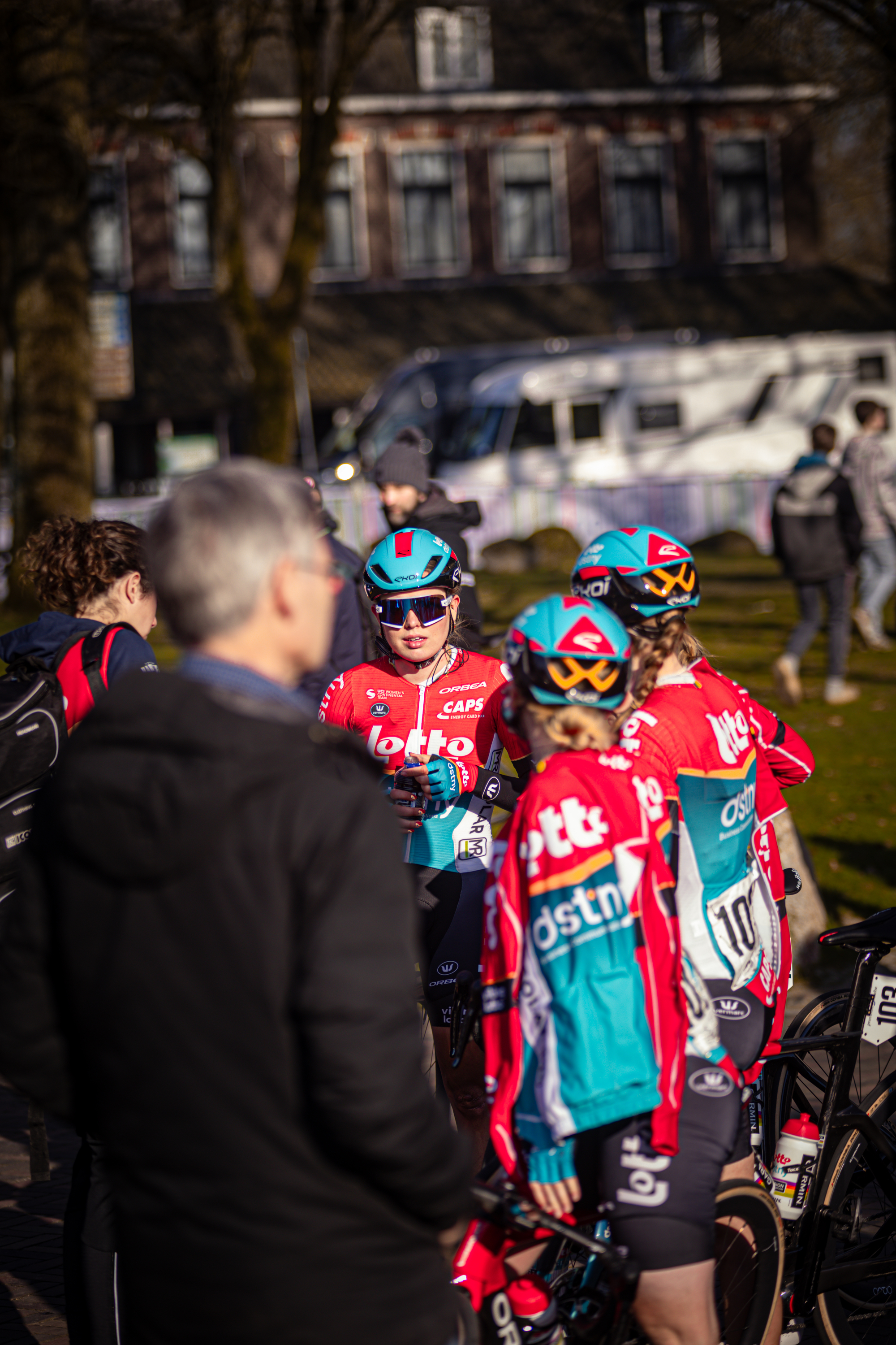 A group of cyclists in blue and red uniforms from the Wielrennen Drentse 8 Van Westerveld event.