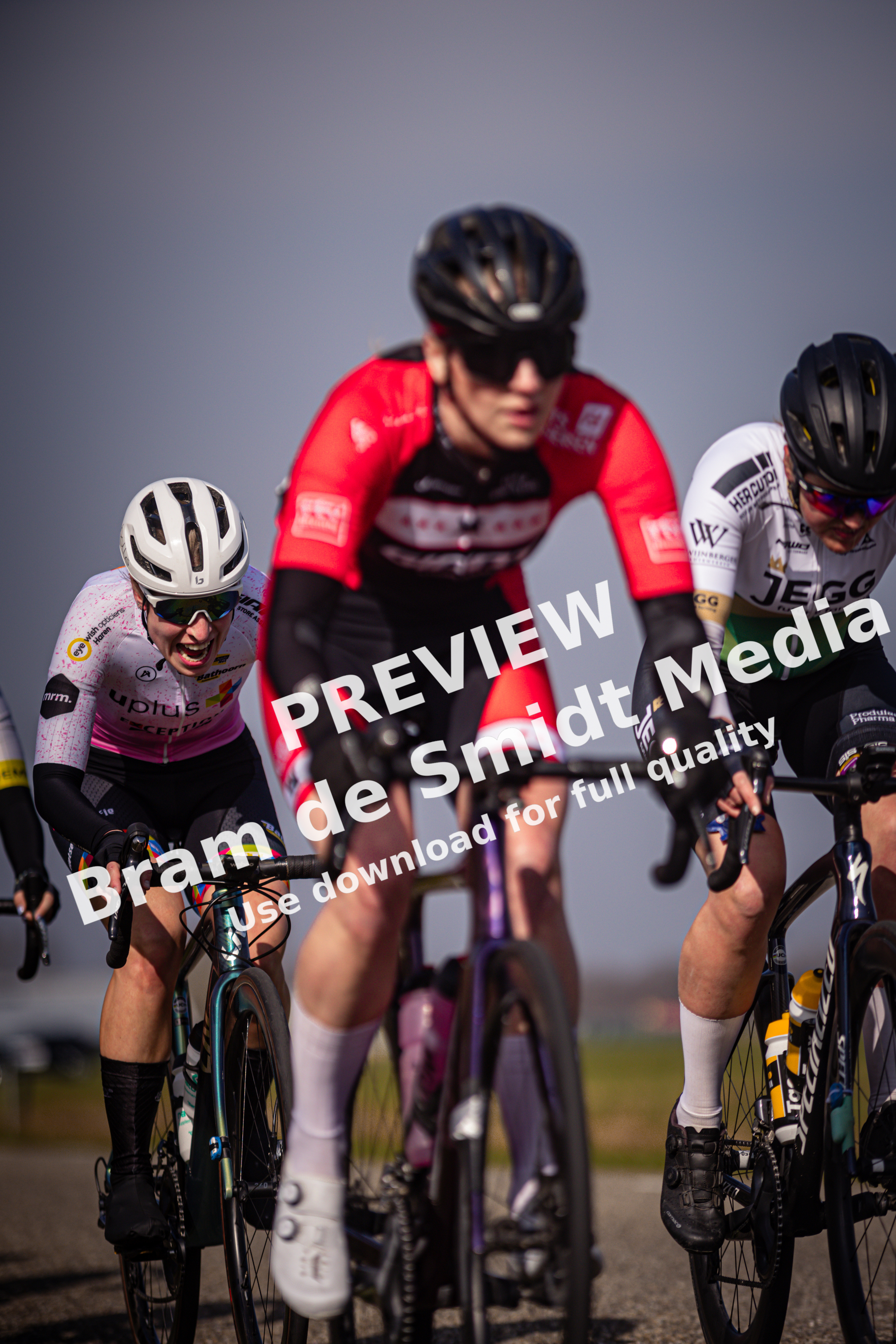 Three people are riding bikes together, with one wearing a red shirt.