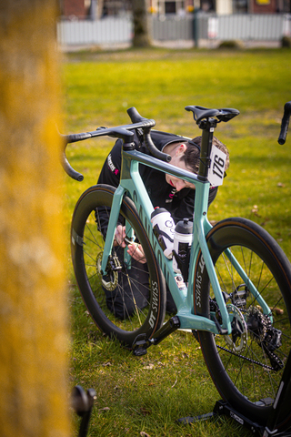 A person is sitting on a blue bicycle with the number 21 on the front.