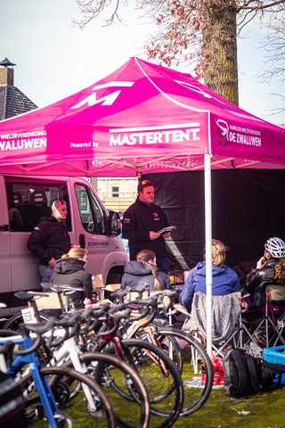 People gathered under a tent with Wielrennen and MasterTent written on it.