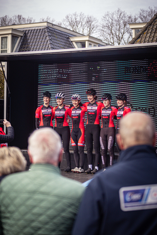 A group of cyclists wear matching red and black outfits sponsored by Rabo.