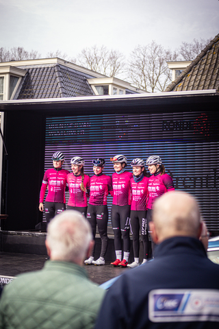 A group of athletes are standing on a stage at the Drentse 8 van Westerveld race.