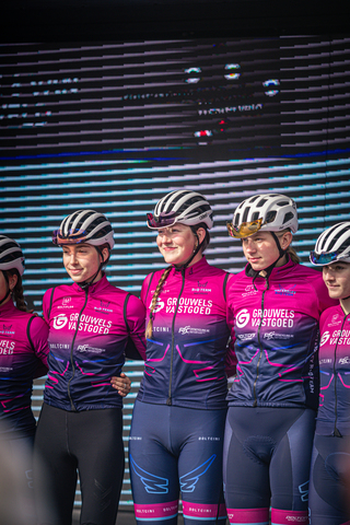 Four cyclists wearing pink and blue uniforms, sponsored by Giro.