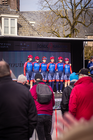 A group of cyclists dressed in red and blue with Wielrennen on their jerseys.