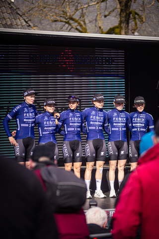 Eight cyclists on a stage at the Drentse 8 van Westerveld race, lined up for a group photo.