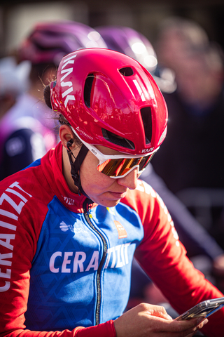 A person in a red and blue top, wearing sunglasses and a red bike helmet with "Giant" written on it.