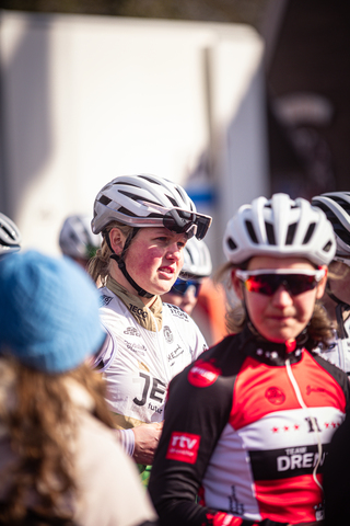 Four women wearing helmets, two with bikes on their head and one is on her head.