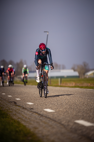 A person on a bicycle wearing red and blue cycling gear.