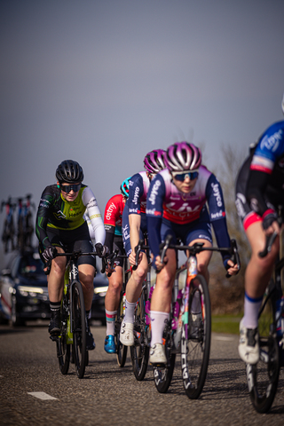 Four women on a cycling race sponsored by Wielrennen.