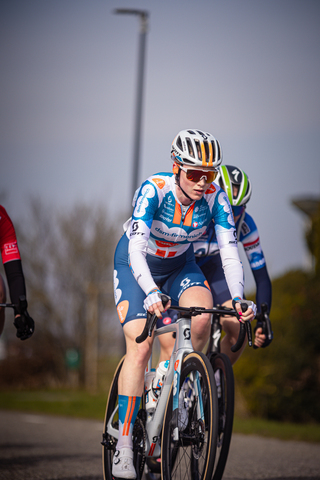 A cyclist wearing a blue and white jersey is riding on a bike.