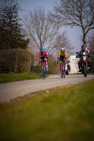 A group of cyclists riding through a park in Drentse 8 van Westerveld.