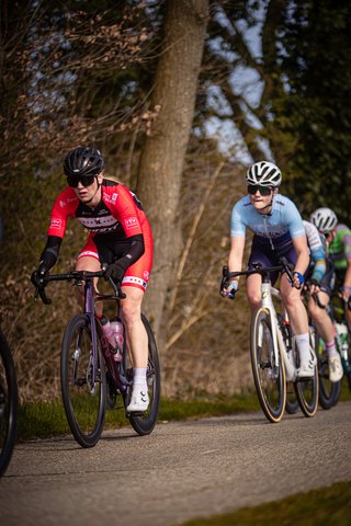 Three cyclists racing down a road on what appears to be Drentse 8 van Westerveld, the course of the race.