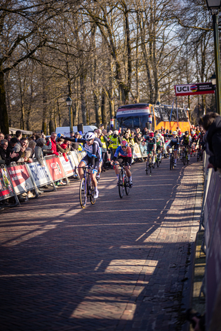 A group of cyclists compete in the Drentse 8 van Westerveld race on a sunny day.