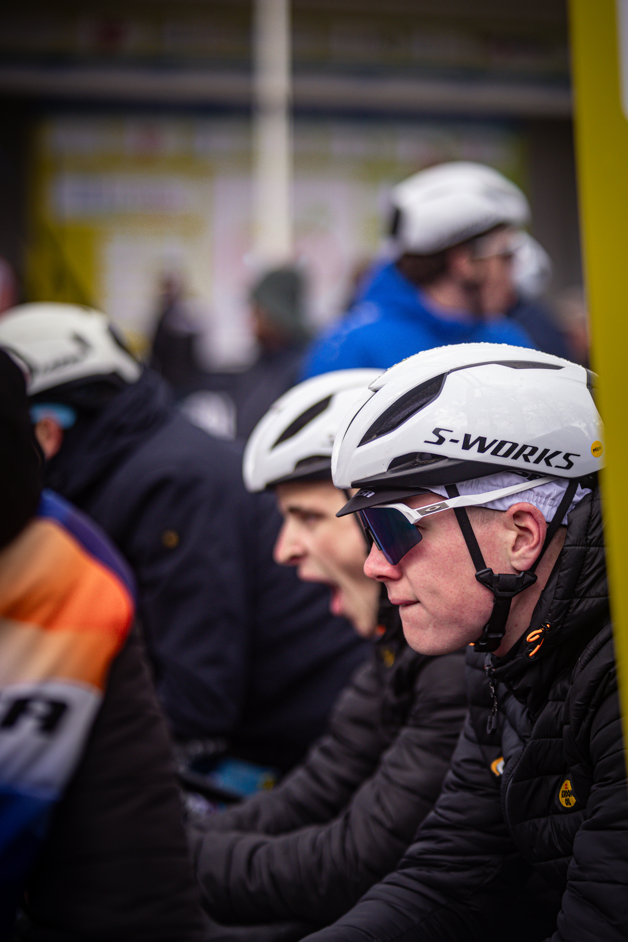 A racer is wearing a white helmet with black logos that say S-Works.