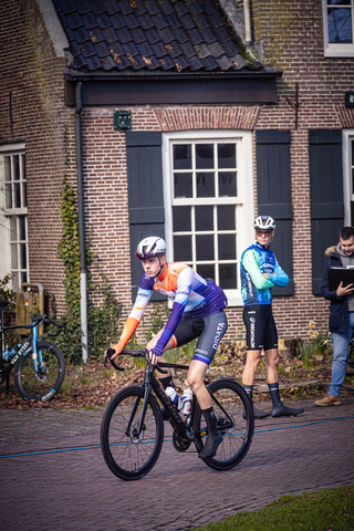 A cyclist in a blue jersey is racing through the streets during the Tour de France.