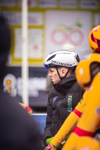 A man wearing a bike helmet with a bicycle on the front of it.