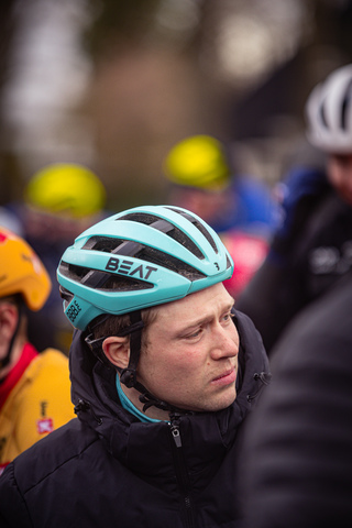 Bike racer wearing a teal helmet and black jacket is about to turn in the 2024 Olympics Tour Stage 4.