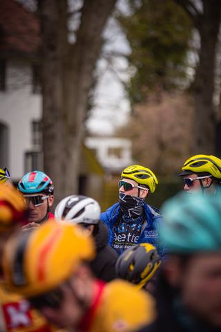 A group of cyclists are riding through a tree-lined street in the Netherlands during the Tour de France.