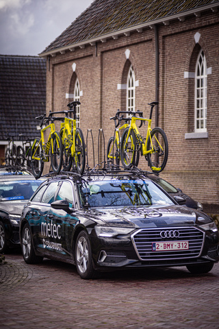 An Audi SUV has a bike rack on the roof with two bikes on top.