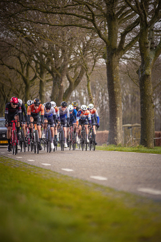 A group of cyclists riding down a road in the Tour de France.